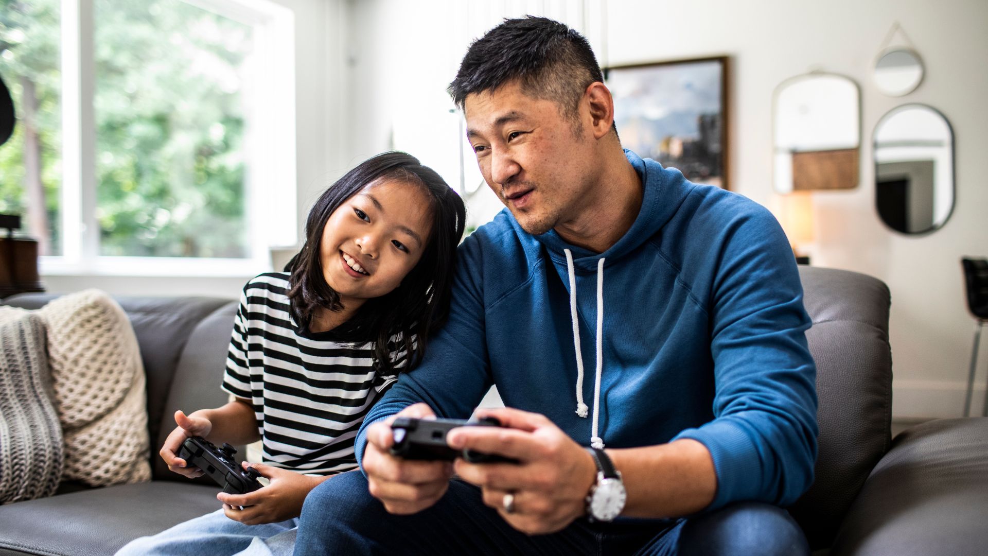 Father and daughter playing video games at home