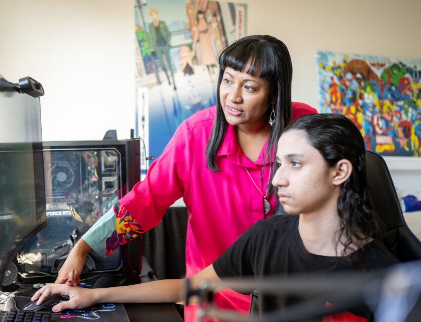 Mother and her son with social anxiety using computer to access the MyIntegra portal which makes NDIS plan management easy and stress free