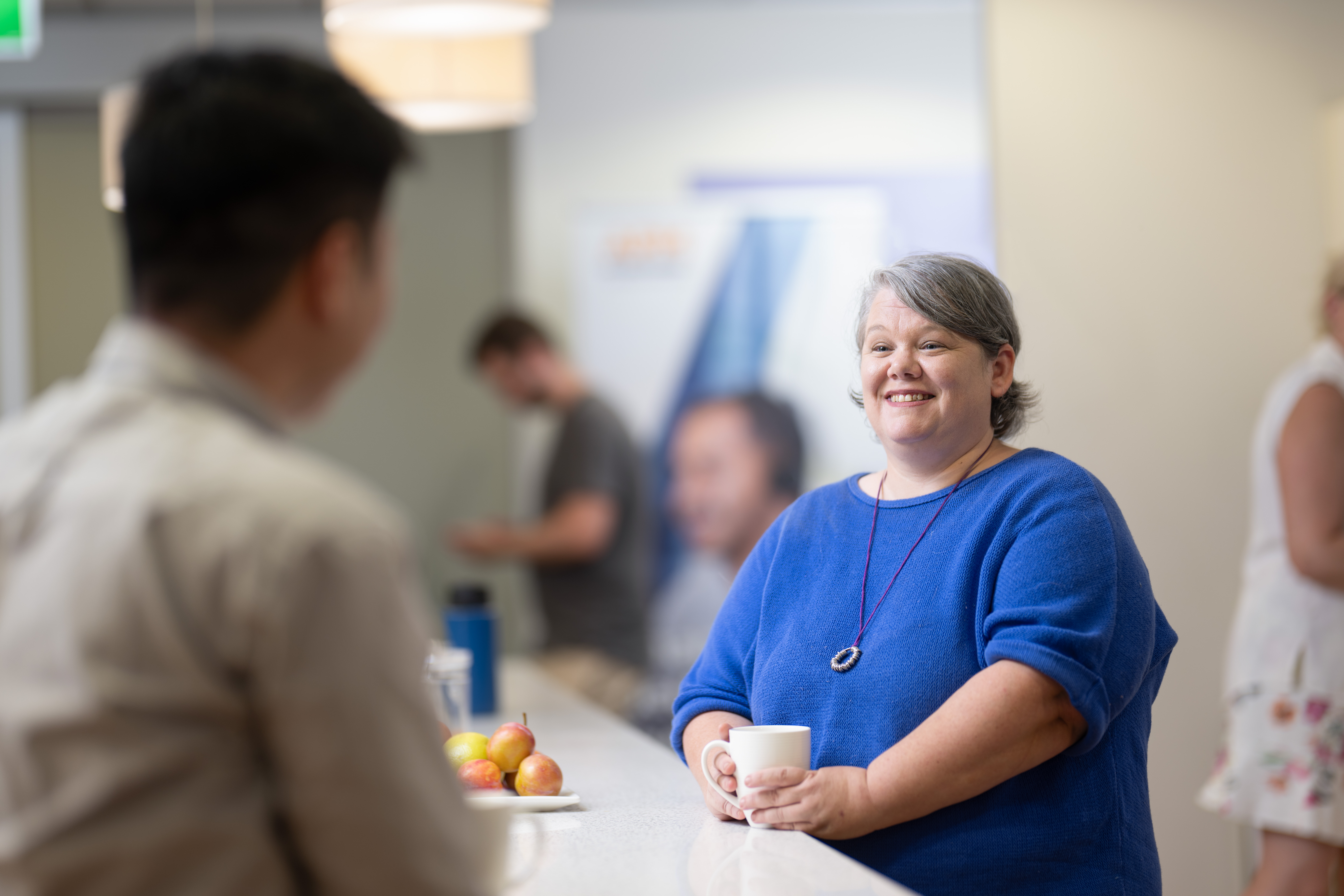 friendly lady smiling while talking to others.