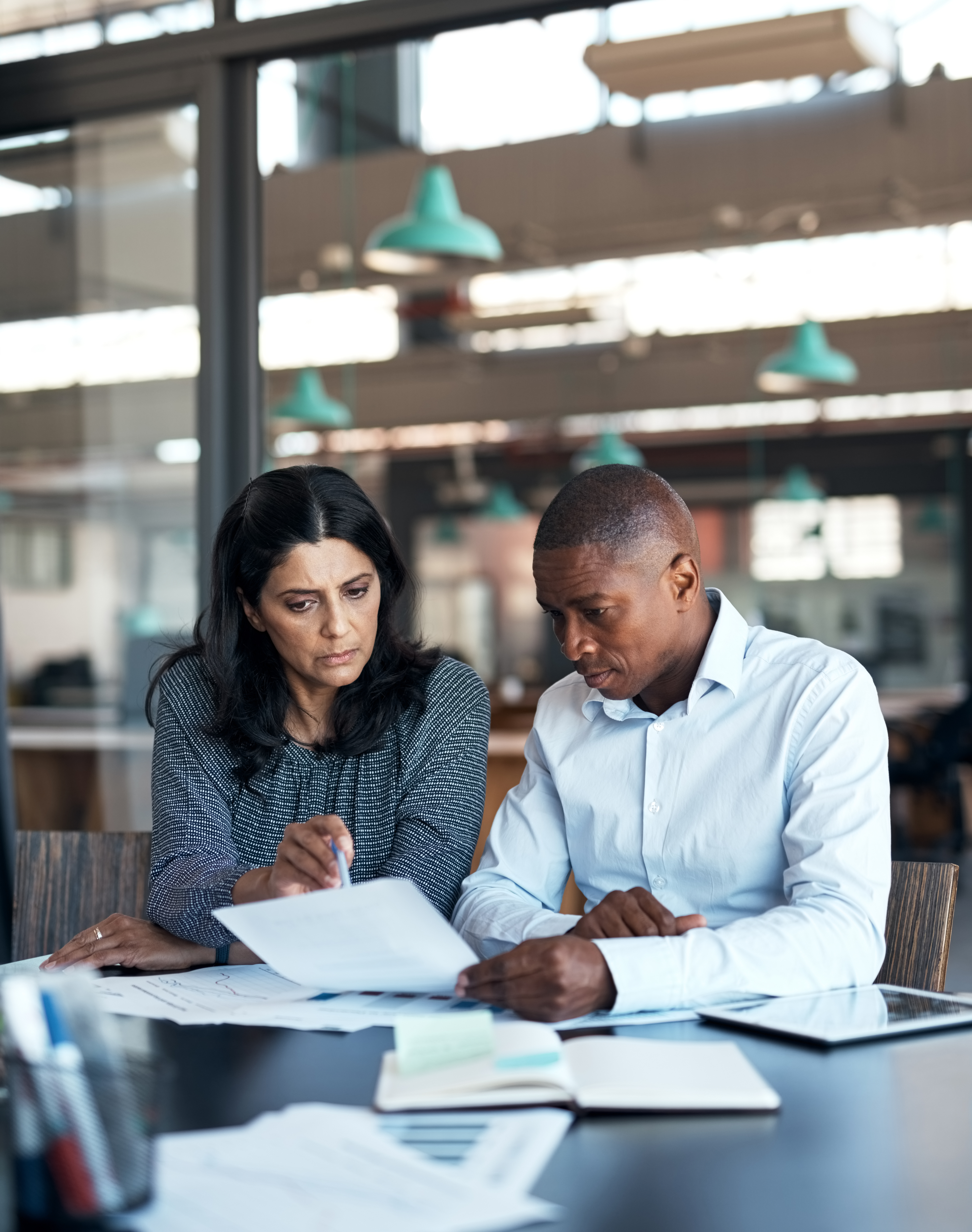 two people working together looking through papers.